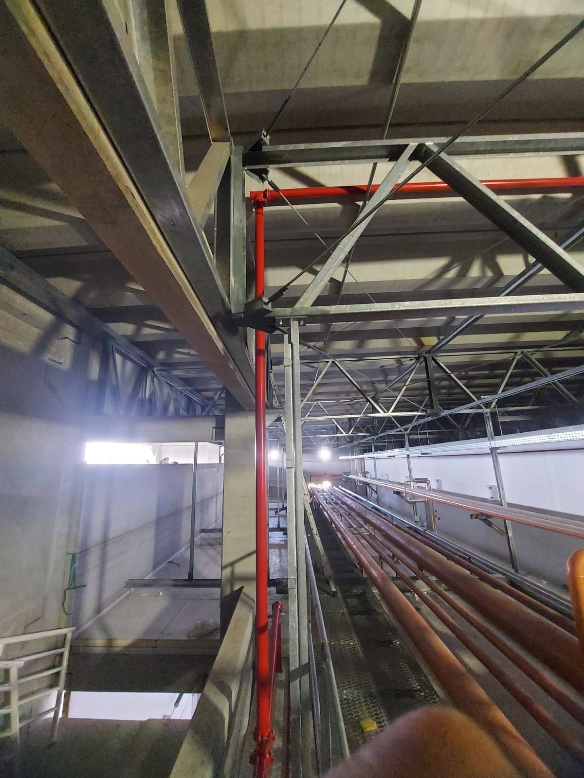 Instalação de tubulação em galeria técnica de prédio industrial
